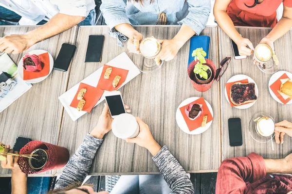 在咖啡馆里喝卡布奇诺的朋友们的热门观点-人们一起吃蛋糕和使用手机智能手机在咖啡厅酒吧-明亮的 azure 过滤器上的友谊概念 — 图库照片