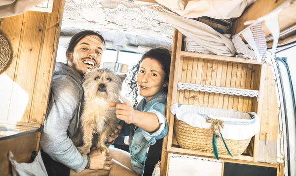 Hipster-Paar mit süßem Hund auf Oldtimer-Minivan-Fahrt - Reise-Lifetstyle-Konzept mit Indie-Leuten auf Minivan-Abenteuerreise mit Spaß im entspannten Moment - Vintage-Retro-Filter — Stockfoto