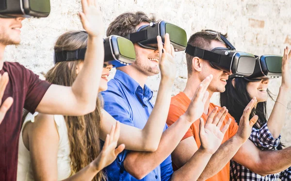 Sekelompok teman bermain di kacamata vr outdoors Virtual augmented reality and wearable tech concept with young people having fun together with headset Digital generation trend Warm bright filter — Stok Foto