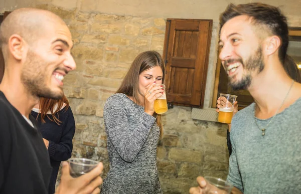 Счастливые друзья, пьющие пиво на дне рождения дома - Концепция дружбы с людьми, веселящимися вместе - Молодые люди, разделяющие момент радости, празднующие дома - Фильтр согревания с акцентом на среднюю девочку — стоковое фото