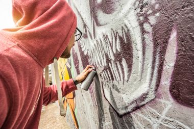 Sokak sanatçı genel duvar - Modern Sanat kavramı ile gerçekleştirme ve multi renk aerosol sprey ile canlı murales hazırlık kentsel guy - Sunshine filtre renkli grafiti canavar odaklanma ile boyama