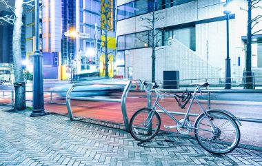 Gece sahne park edilmiş Bisiklet ve Japonya - kentsel seyahat kavramı modern bisiklet üzerinde parlak gök renk filtresi ile şehir merkezi Tokyo başkenti hız araba bulanık
