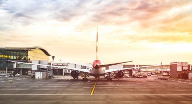 Arkadan görünüşü modern uçak kalkışa hazır terminal kapısında pist - bulutlu gökyüzü ile Uluslararası Havaalanı - seyahat ve Yolculuk tutkusu kavramı dünyanın dramatik kontrast filtre uygulanmış görünüm