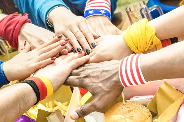 Visão lateral superior de mãos multirraciais de amigo torcedor de futebol compartilhando comida de rua - Conceito de amizade com fã de futebol desfrutando de comida juntos - Pessoas comendo no bar de festa pub após evento de jogo esportivo — Fotografia de Stock