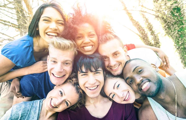 Beste Freunde machen Selfie beim Picknick mit Hintergrundbeleuchtung - fröhliches Jugendfreundschaftskonzept gegen Rassismus mit jungen Leuten, die zusammen Spaß haben - entsättigter Vintage-Filter mit Sonnenscheinwerfer — Stockfoto