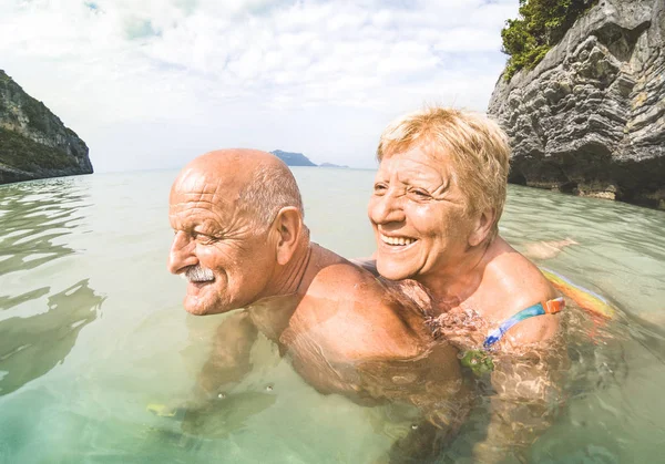 Seniorenpaarurlauber mit echtem spielerischem Spaß am tropischen Strand in Thailand - Schnorcheltour in exotischem Szenario - aktive Senioren und Reisekonzept rund um die Welt - warmer Nachmittag mit hellem Filter — Stockfoto
