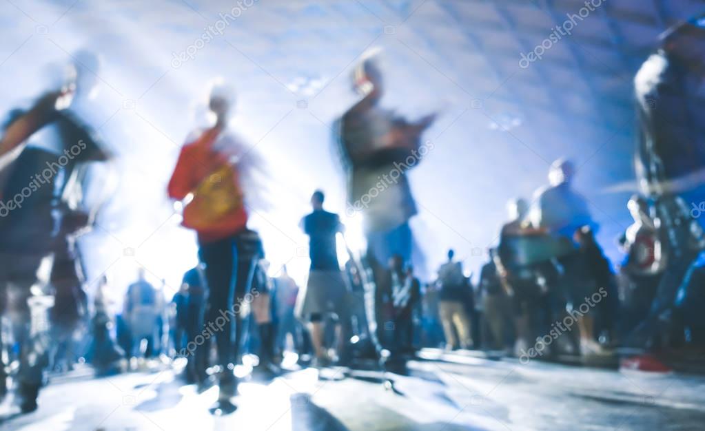 Abstract blurred people moving on and dancing at music night festival event - Defocused image of disco club party with laser show - Nightlife entertainment concept - Azure contrast spotlight filter