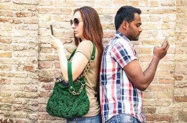 Sıkılmış çok ırklı çift mobil akıllı telefon - bağımlılığı izolasyon kavramı ile smartphone - sevgili ilgisizlik an kullanan millennials gençlerin - sıcak tarafsız filtre kullanma