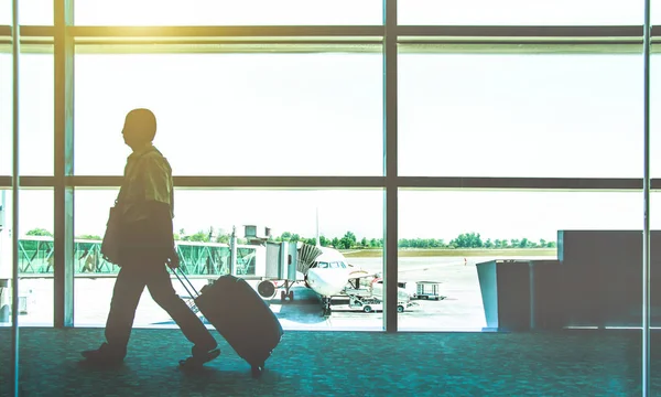 Traveler mannen på internationella flygplats flyttar till terminal gate för flygplan resa resa - rörlighet koncept och flygindustrin flygförbindelser - solsken på kallt blått nostalgisk filter färgton — Stockfoto