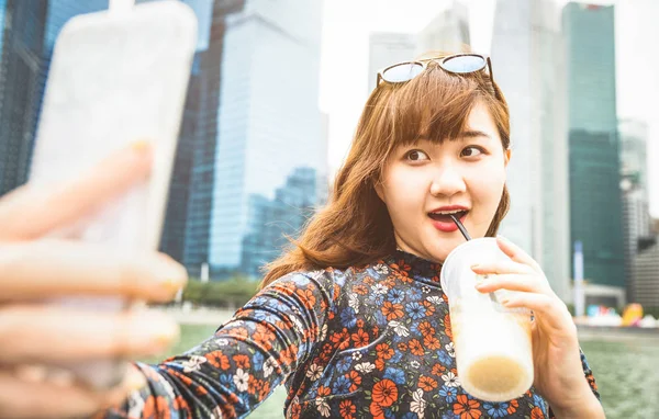 Perempuan Asia cantik pengembara mengambil selfie di daerah perkotaan modern Teluk Marina di kaki langit Singapura saat matahari terbenam - Gaya hidup perjalanan petualangan di sekitar ibu kota Asia Tenggara - Filter terang yang hangat — Stok Foto
