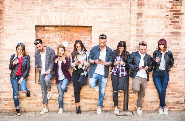 Freundeskreis mit Smartphone gegen Wand in Uni-Hinterhofpause - Junge Leute süchtig nach Handy - Technologiekonzept mit immer vernetzten Millennials - Filterbild — Stockfoto