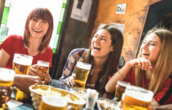 Happy girlfriends women group drinking beer at brewery bar restaurant - Conceito de amizade com jovens amigas aproveitando o tempo e se divertindo genuinamente no pub vintage legal - Concentre-se na garota esquerda — Fotografia de Stock