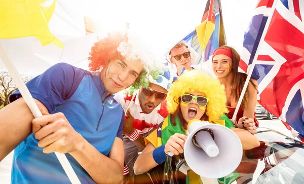 Aficionados aficionados al fútbol amigos animando después de partido de Copa de fútbol colgando alrededor con el coche y banderas - Grupo de jóvenes con camisetas multicolores que se divierten emocionados en el concepto de campeonato mundial de deporte —  Fotos de Stock