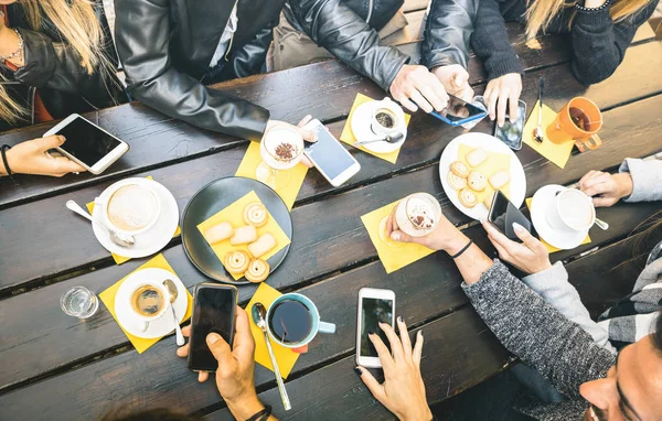 Ovanifrån vänner dricka cappuccino på kafé restaurant - människor som har roligt tillsammans äta kakor och använda mobila smarta telefoner på café bar - vänskap koncept på ljusa vintage filter — Stockfoto