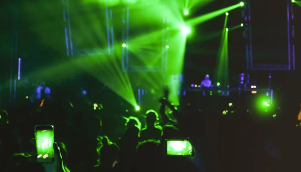 Persone offuscate che ballano all'evento del festival notturno di musica - Abtsract immagine sfocata sfondo della discoteca dopo la festa con spettacolo laser - Concetto di intrattenimento notturno - Filtro riflettore verde brillante — Foto Stock