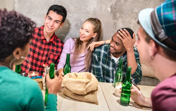 Millenial friends group drinking bottle beer and having fun at fashion cocktail bar restaurant - happy multi-racial friendship concept with young people enjoy time talking together at brewery pub — Stockfoto