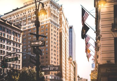 New York 'ta gün batımında Broadway ve Batı 35. Cadde arasındaki tabelalar - Manhattan şehir merkezinde şehir konsepti ve yol yönü - Amerika' nın dünyaca ünlü sermaye hedefleri - sıcak kontrast filtresi