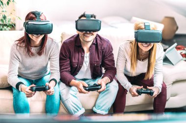 Evde video gözlüklerle oynayan milenyum arkadaşları - Sanal gerçeklik ve kulaklıkla eğlenen gençlerle giyilebilir teknoloji konsepti - Z nesli dijital trendler - ortadaki adama odaklan