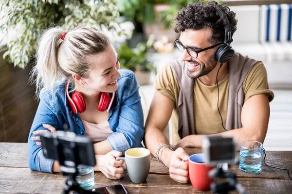 Young millenial couple sharing creative content online on webcam - Digital marketing concept with next generation influencer having fun on radio video stream - Vlogging time at startup coworking space — Stock Photo, Image