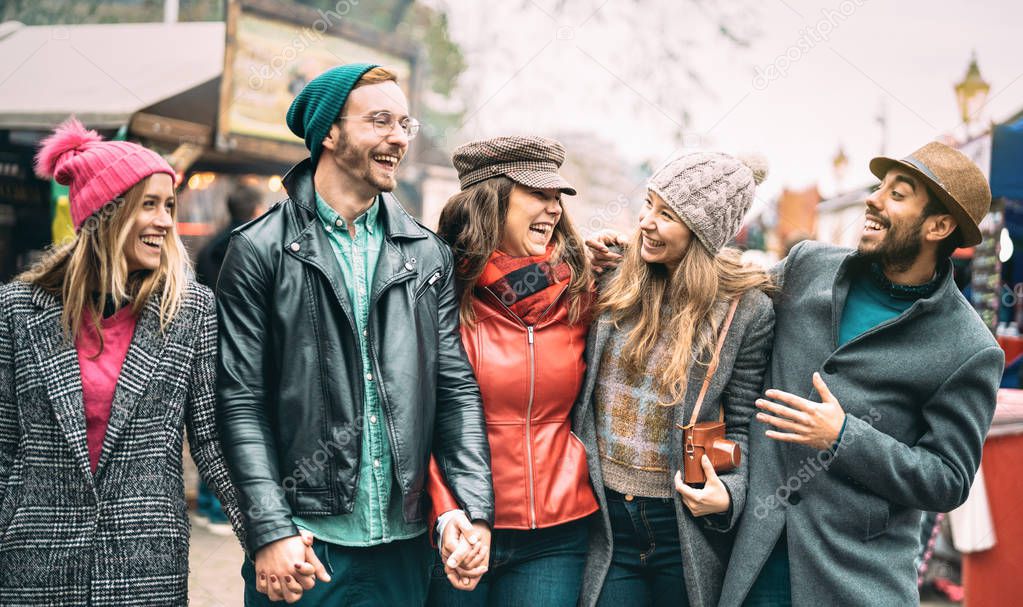 Millennial friends group walking at London city center - Next generation friendship concept on multicultural young people wearing winter fashion clothes having fun together in UK - Warm vintage filter