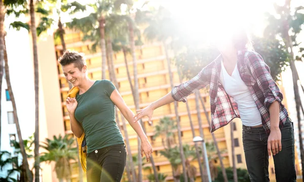 Mulheres felizes namoradas apaixonadas compartilhando o tempo juntos andando no parque - Carefree lgbtq e conceito de amizade feminina com meninas casal se divertindo ao ar livre - filtro de luz solar quente retroiluminado — Fotografia de Stock