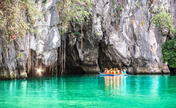 Cave entrance of Puerto Princesa subterranean underground river with longtail boat - Wanderlust travel concept at Palawan exclusive Philippine destination - Vivid filter with bulb torch light sunflare — Stock Photo, Image