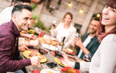 Mutlu çift çatıdaki partide arkadaşlarıyla kırmızı şarap içiyor, genç adam güzel bir kadınla içki içiyor, milenyumlarla arkadaşlık kavramı birlikte eğleniyor, cam odaklı sıcak, parlak bir filtre.