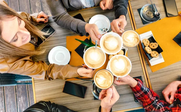 Top view of friends toasting cappuccino at coffee shop restaurant - Millennial students group having fun on breakfast together at fashion cafe bar - Cafeteria drinks concept on vivid warm filter — Stock Photo, Image