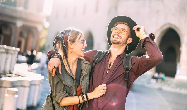 Happy couple in love having candid fun walking in city center - Wanderlust life style and travel vacation concept with guy and girl at old town tour on warm sunshine filter and backlighting — Stock Photo, Image