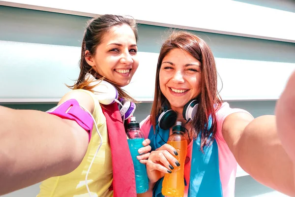 Happy girlfriends taking selfie on break at run training in urban area - Young happy women having fun together with fitness jogging workout - Sport influenceur concept promoting energetic drinks — Photo