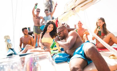 Multiracial friends having fun at sailboat party with dj set - Wanderlust travel concept with young people on sailing trip - Luxury lifestyle on exlusive summer mood - Warm sunshine halo filter