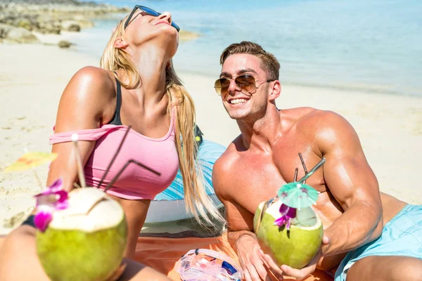 Young couple vacationers drinking cocunut cocktail and having fun on tropical beach in Phuket Thailand - Luxury travel concept with people in love around the world - Bright warm color tones — Stock Photo, Image