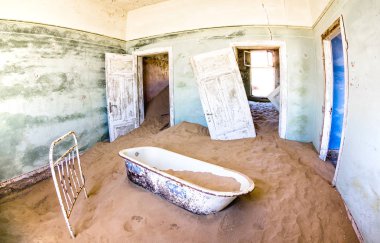 Namibya 'nın Luderitz yakınlarındaki terk edilmiş hayalet şehir Kolmanskop' ta çölden gelen kum dolu terk edilmiş bir ev. Gezgin şehvet ve seyahat konsepti Güney Afrika harikalarını araştırıyor.