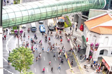 Singapur - 14 Şubat 2015: Orchard Road Gateway 'in altındaki zebra geçitlerinde yürüyen insanların günlük hayatı - Şehir merkezindeki kalabalık saat - binanın tepesinden sokak manzarası