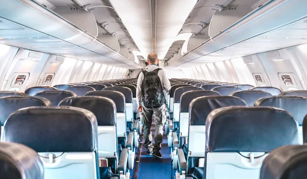 孤独な男の旅行者と商業飛行機の内部ビュー フライトキャンセルについての緊急旅行の概念 明るい紺碧のフィルター上の空の飛行機と航空宇宙産業の危機 — ストック写真