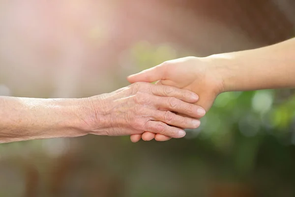 Aiutare le mani. Mani di giovani donne adulte e anziane. Concetto anziano . — Foto Stock