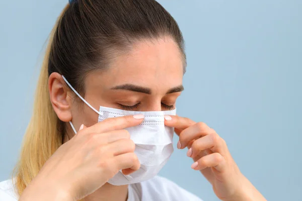 Istruzione, come indossare la maschera protettiva medica. La ragazza indossa una maschera medica. Fase 4 . Foto Stock Royalty Free