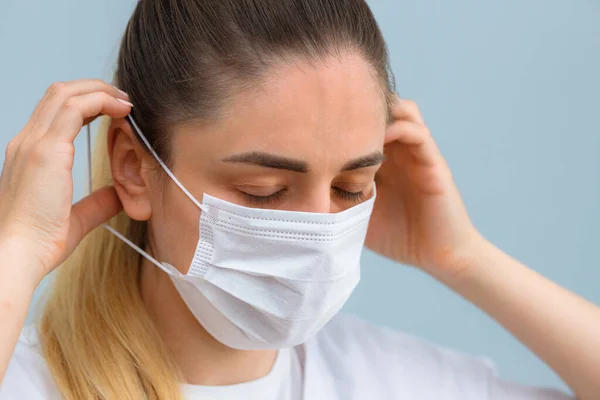 Istruzione, come indossare la maschera protettiva medica. La ragazza indossa una maschera medica. Fase 3 . Immagine Stock