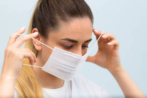 Instrução, como pôr a máscara protetora médica. A rapariga usa máscara médica. Passo 2 Imagem De Stock