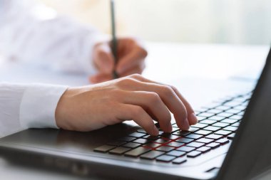 Klavyeye yazı yazan bir kadın eli. Uzaktan öğrenme, online eğitim. Evden, iş yerinden ve teknoloji konseptinden çevrimiçi çalışma