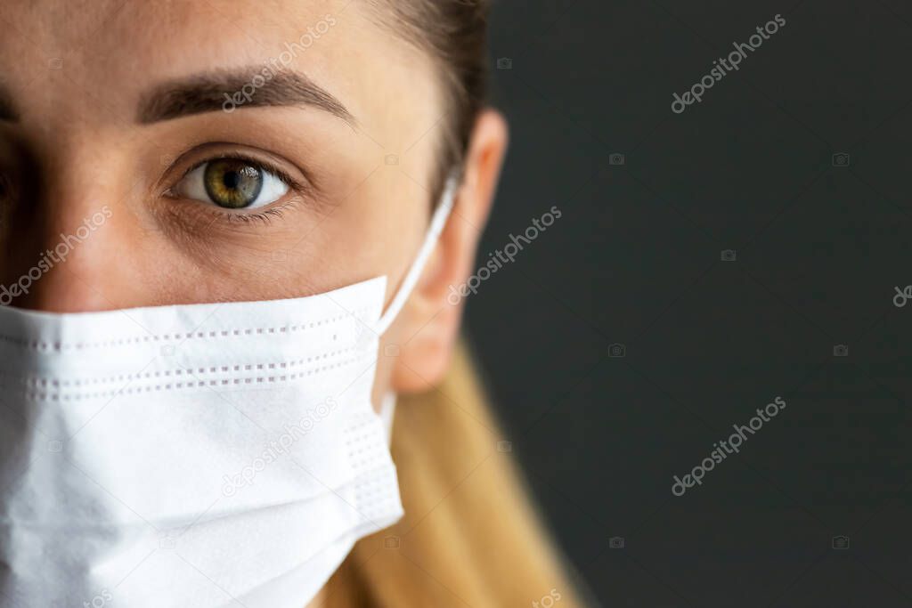 Close up of infected girl on dark background in medical protective mask. Concept of infection control. Medical concept.