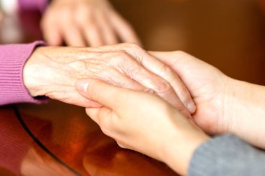 Yardım eli uzatıyorum. Genç yetişkin ve yaşlı kadınların elleri. Bakım ve yaşlılık kavramı.