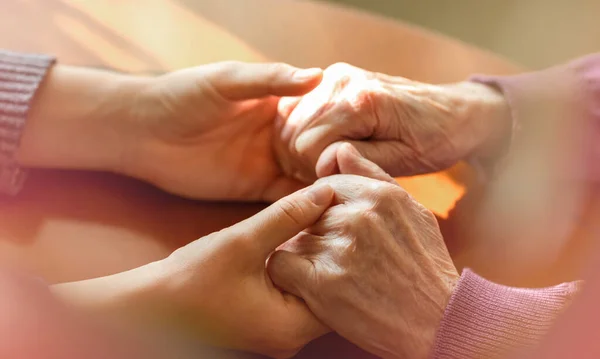 Mani anziane. Aiutare le mani di giovani donne adulte e anziane. Cura e concetto di anziani . — Foto Stock