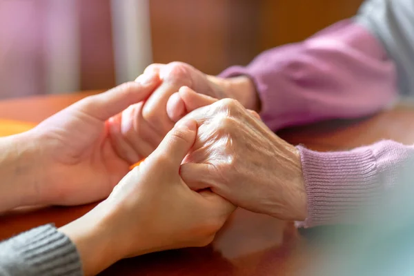 Mani anziane. Aiutare le mani di giovani donne adulte e anziane. Cura e concetto di anziani . — Foto Stock