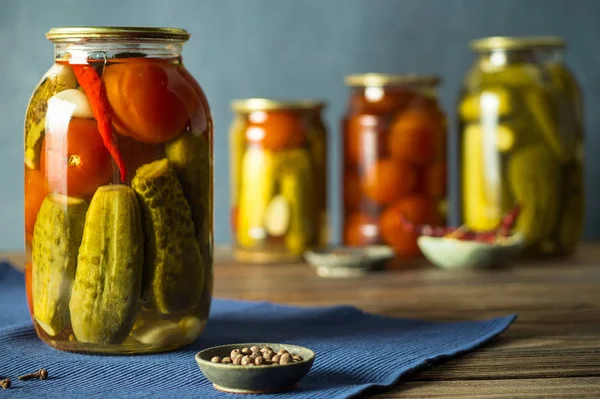 Banks with fermented cucumbers, tomatoes and pepper with seasonings. — Stock Image Banks with fermented cucumbers, tomatoes and pepper with seasonings. Stock Picture
