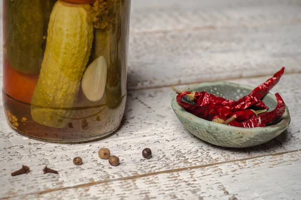 Jar of fermented cucumbers and hot pepper sauce pot close-up. — Stock Image Jar of fermented cucumbers and hot pepper sauce pot close-up. Royalty Free Stock Images