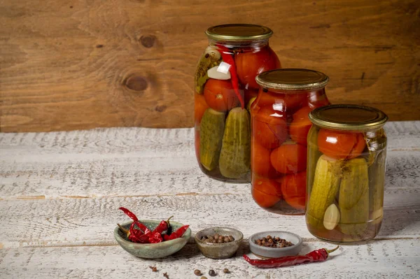 Jars with assorted fermented cucumbers and tomatoes with seasonings. — Stock Image Jars with assorted fermented cucumbers and tomatoes with seasonings. Royalty Free Stock Images