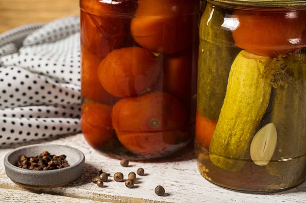 Jars of fermented cucumbers and tomatoes gravy boat with cloves close-up. — Stock Image Jars of fermented cucumbers and tomatoes gravy boat with cloves close-up. Stock Photo