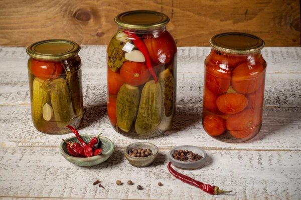 Jars with assorted fermented cucumbers and tomatoes with seasonings. — Stock Image Jars with assorted fermented cucumbers and tomatoes with seasonings. Stock Image