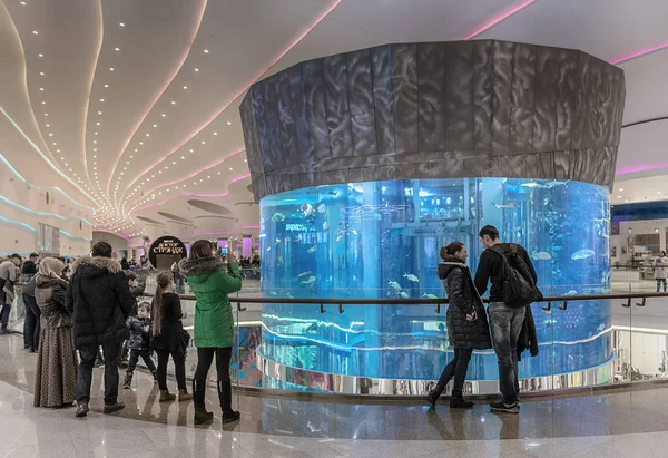 Moscovo. 5 Novembro 2016. O centro comercial "Oceania", último andar. Adultos e crianças caminham pelo aquário cilíndrico e admiram os peixes exóticos . — Fotografia de Stock